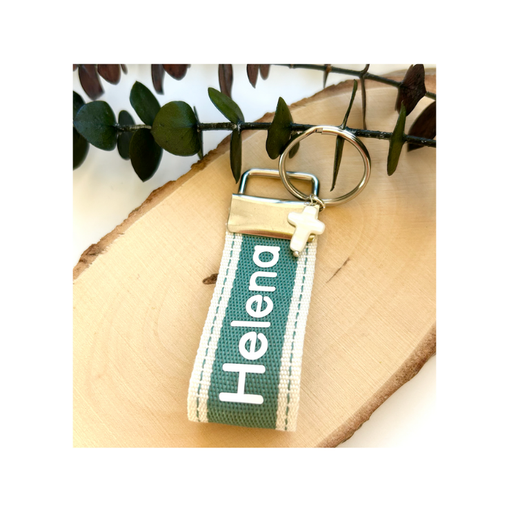 Llavero de tela verde con el nombre Helena bordado y cruz de nácar
