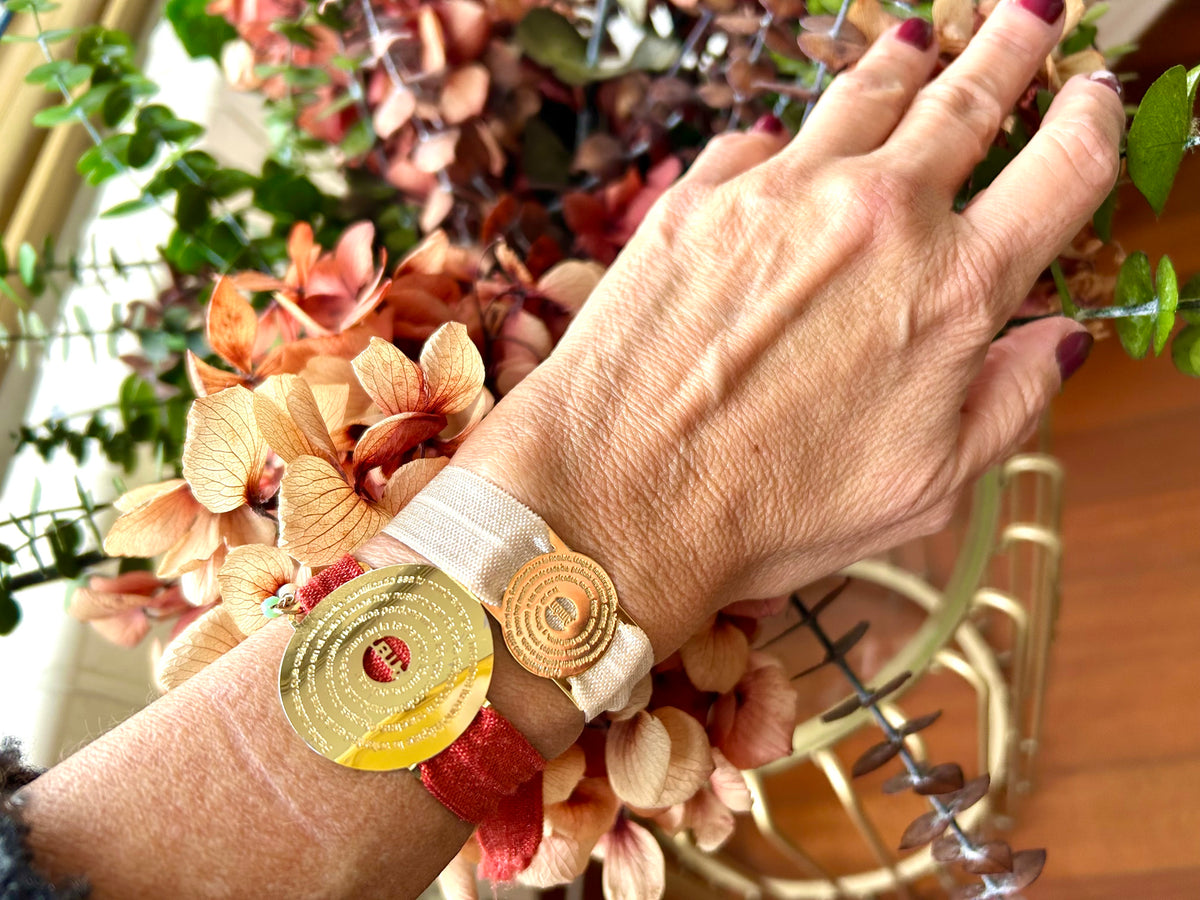 Pulsera con medalla del Padre Nuestro en goldfilled puesta en la muñeca
