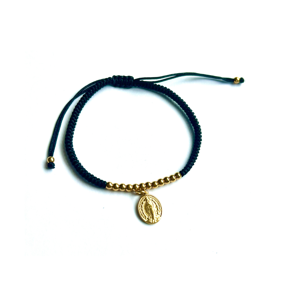 Pulsera adaptable de hilo azul marino con bolitas doradas y medallita ovalada de la Virgen