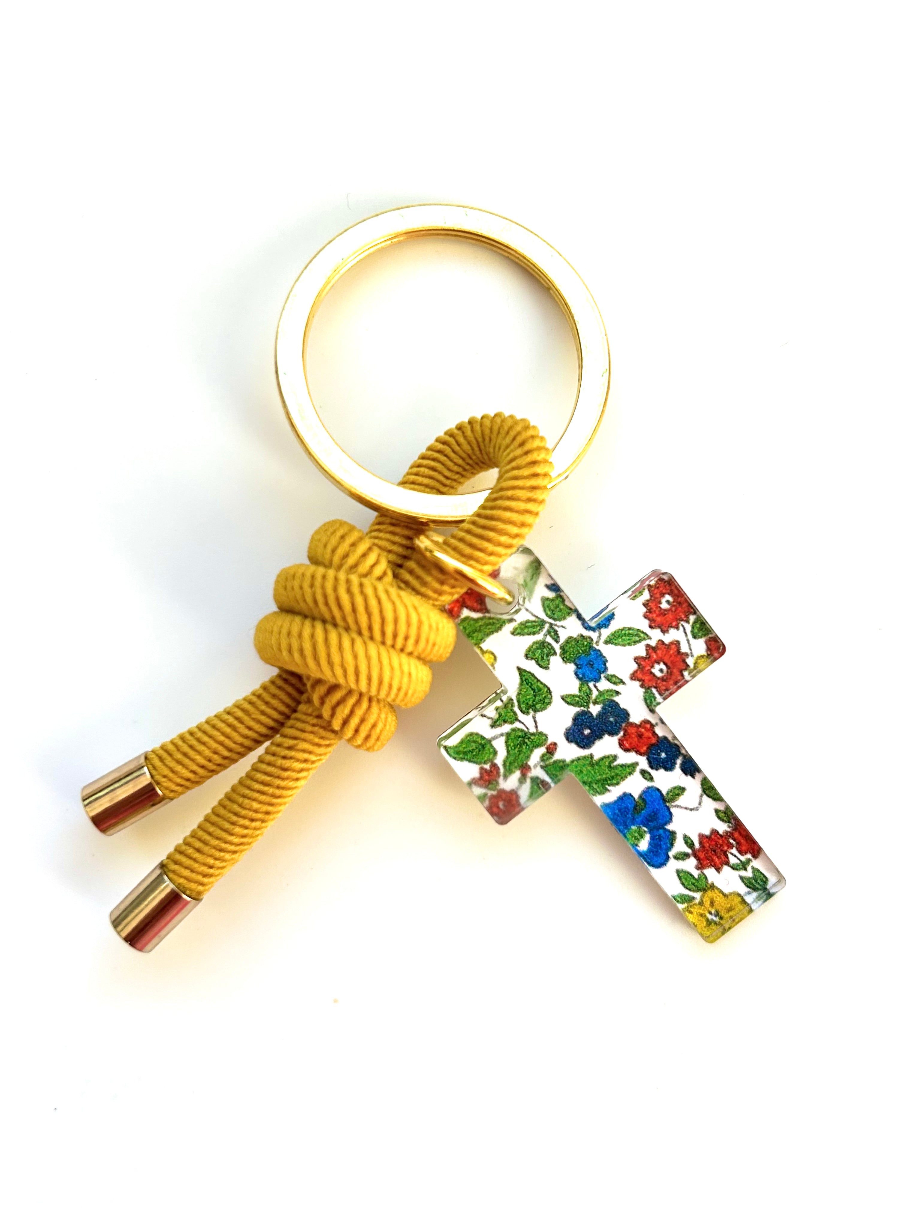 Llavero de cordón mostaza con cruz de liberty de flores