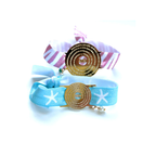 Dos pulseras elásticas con medalla del Padre Nuestro en goldfilled, con cinta estampada rosa y azul