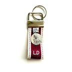 Llavero de tela granate con iniciales bordadas y medalla