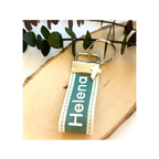 Llavero de tela verde con el nombre Helena bordado y cruz de nácar