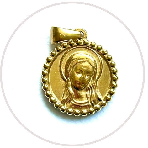 Medalla de la Virgen Niña de acero dorado con borde de bolitas, de cerca